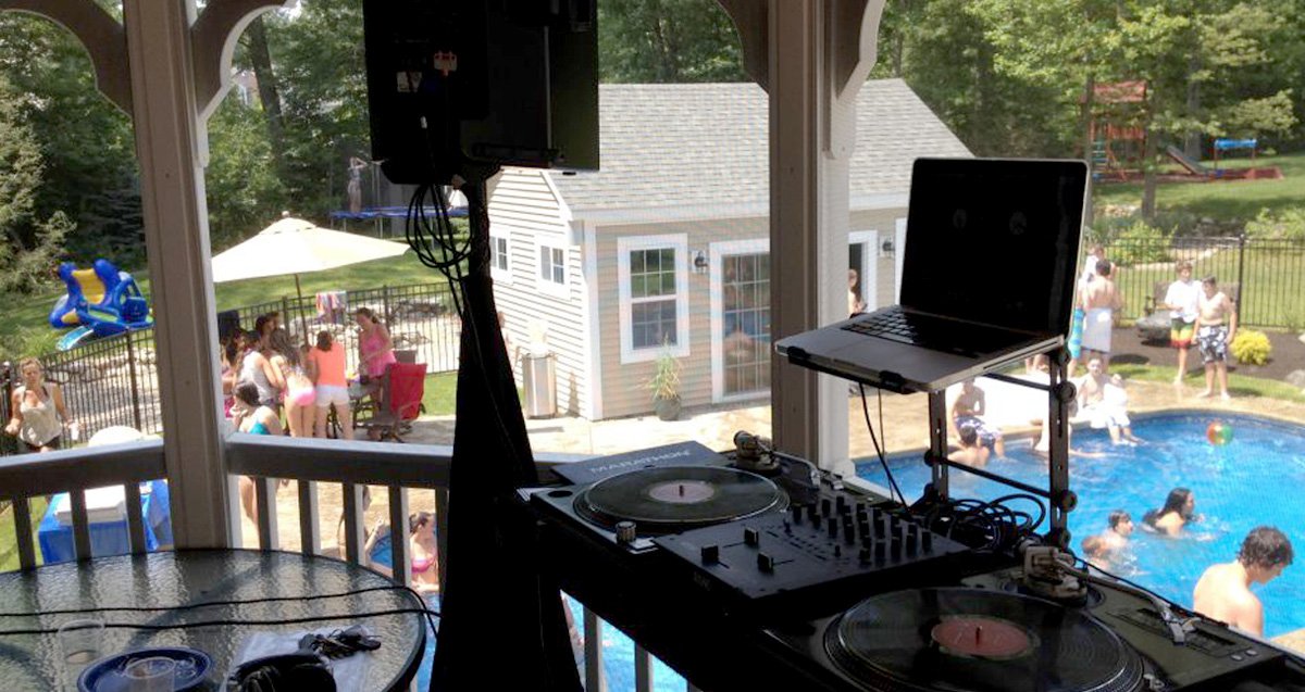 Seacoast DJ setup overlooking a backyard pool party